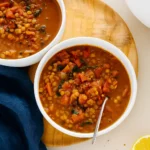 Best Lentil Soup in a rustic bowl with steam and lemon
