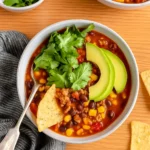 Healthy Taco Soup in rustic bowl with toppings
